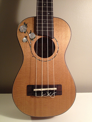 Treble-Rose ukulele with mother of pearl inlay made in Koa with spruce top and rosewood highlights front view